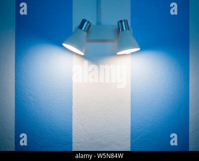 Lampada da parete in bianco e blu a strisce sullo sfondo della parete con copia spazio. Foto Stock