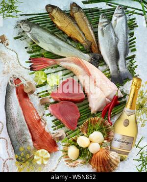 Selezione di diverse materie e pesce affumicato, cozze, bottiglia di champagne, su ghiaccio, Germania Foto Stock