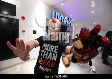 Un Cinese filmgoer indossando il ferro uomo casco attende all'interno di un cinema prima della mezzanotte premiere di Disney e la meraviglia del " vendicatori: Endgame' in Shangh Foto Stock