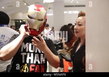 Un Cinese filmgoer indossando il ferro uomo casco attende all'interno di un cinema prima della mezzanotte premiere di Disney e la meraviglia del " vendicatori: Endgame' in Shangh Foto Stock