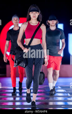 Un modello consente di visualizzare una nuova creazione al Tmall fashion show luluemon in Cina a Shanghai, 27 aprile 2019. Foto Stock