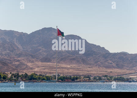 Aqaba Giordania - 6 Novembre 2017: Bandiera della Giordania sventolare sopra la città. Bandiera araba di Revolt-Sixth più alto pennone del mondo. Foto Stock