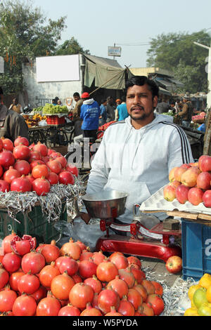 Uomo di frutti di vendita in un mercato in stallo Foto Stock