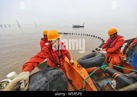 Cinese del lavoro workders presso il cantiere per la costruzione della 500 kilovolt (KV) ultra-alta tensione Cavi sottomarini al di sotto del Zhoushan stretto in Zhoushan c Foto Stock