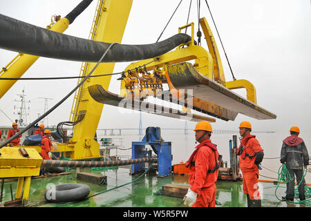 Cinese del lavoro workders presso il cantiere per la costruzione della 500 kilovolt (KV) ultra-alta tensione Cavi sottomarini al di sotto del Zhoushan stretto in Zhoushan c Foto Stock