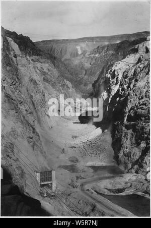 Guardando a monte attraverso Canyon Nero verso la Hoover Damsite mostra in che misura il livello inferiore del canyon è soffocato con detriti sabbiata e spogliato da riscontri e pareti del canyon. Portale di uscita del tunnel di deviazione n. 2 temporaneo e di barriera di risacca si vede in primo piano.; Portata e contenuto: fotografia dal volume due di una serie di album di foto per documentare la costruzione della Diga di Hoover, Boulder City, Nevada. Foto Stock