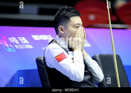 Ding Junhui della Cina un reagisce come egli compete contro la Norvegia nel Gruppo a corrispondere durante il Beverly 2019 Snooker di Coppa del Mondo a Wuxi, est della Cina di Foto Stock