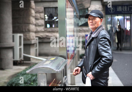 --FILE--un uomo anziano fuma davanti ad un ospedale nella città di Hangzhou, a est della Cina di provincia dello Zhejiang, 2 gennaio 2019. Il fumo ha subito un declino su Foto Stock