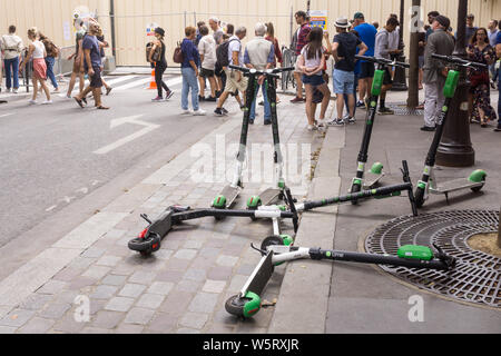 Parigi e-scooter - scooter elettrici a sinistra sul terreno su una strada di Parigi, in Francia, in Europa. Foto Stock