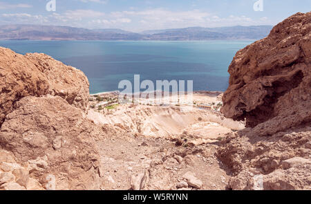 Il mar morto ed Ein Gedi scuola sul campo dal di sopra vicino a David cade con la Giordania Moav montagne sullo sfondo e un grinning boulder in avanti Foto Stock