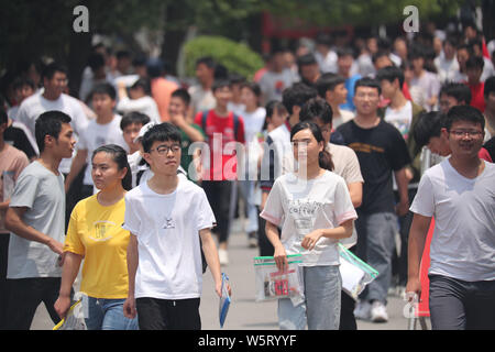 Una folla di giovani studenti cinesi examinees a piedi fuori da una scuola media dopo la finitura del primo esame della relazione nazionale annuale collegio ingresso Foto Stock