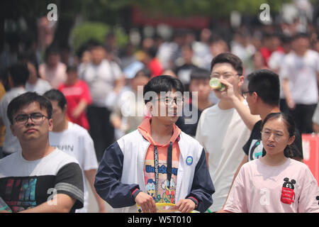 Una folla di giovani studenti cinesi examinees a piedi fuori da una scuola media dopo la finitura del primo esame della relazione nazionale annuale collegio ingresso Foto Stock