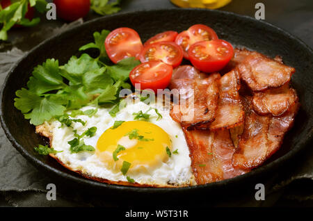 Antipasto uova fritte con pancetta, le verdure e le erbe aromatiche in padella Foto Stock