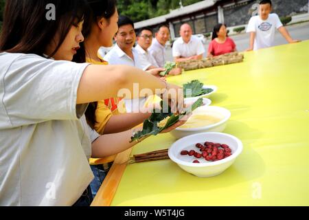 I residenti locali rendono Zongzi, una sorta di grandi riso glutinoso gnocchi di patate, con forma di 'Flying Dragon", precedendo il cinese Dragon Boat Festival o Foto Stock