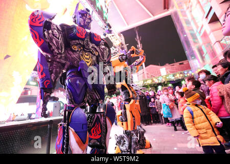 Uno studente di college che indossa un due-metro-high life-size replica di Megatron è circondato da clienti presso un centro commerciale per lo shopping a Xi'an City, a nord-ovest della Cina" Foto Stock