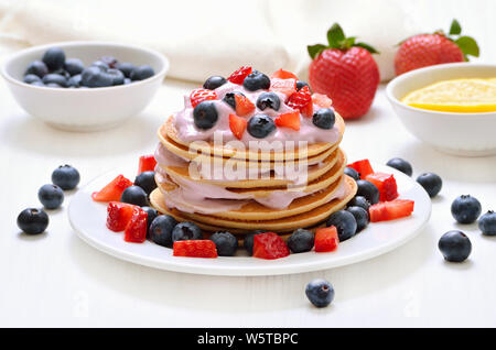 Frittelle con yogurt alla frutta fresca, fragola e mirtillo Foto Stock