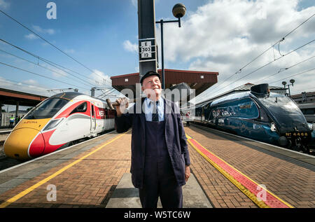 Con trazione a vapore ispettore Jim Smith è raffigurato con un nuovo treno di Azuma accanto il Germano Reale locomotiva a vapore presso la stazione di York, nello Yorkshire, come Londra Nord Est della ferrovia nuova Azuma service è avviato. Foto Stock