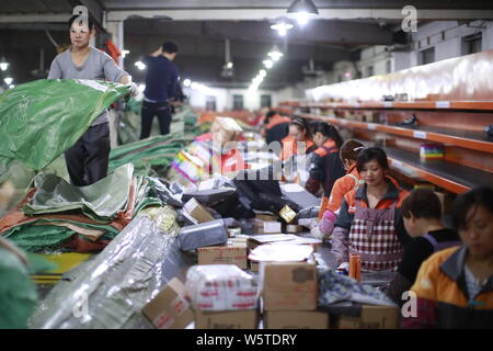 --FILE--lavoratori cinesi ordinamento pacchi, la maggior parte delle quali sono singole' giorno per lo shopping online, presso un centro di distribuzione di STO Express o Shentong Express Foto Stock