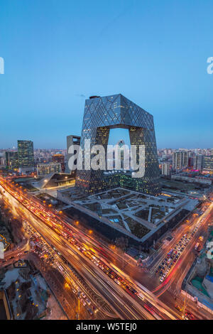 Una vista notturna delle strade trafficate con le masse dei veicoli nella parte anteriore della nuova torre di TVCC nel quartiere centrale degli affari (CBD) a Pechino in Cina, 27 dic Foto Stock