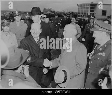 Fotografia del Primo Ministro britannico Clement Attlee stringono le mani con il Segretario di Stato James Byrnes al momento del suo arrivo in aeroporto nazionale di Washington. Foto Stock