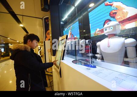 Un robot intelligente serve tè latte ai clienti in un latte tea shop gestiti da robot a un centro commerciale per lo shopping nella città di Hangzhou, a est della Cina di Zhejiang pro Foto Stock