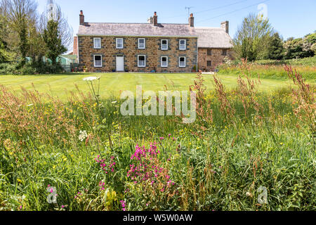 Isola di tipica architettura - Les Caches Farm, Les Villets, Guernsey, Isole del Canale della Manica UK - nuova azienda a metà del XIX C sulla sinistra - vecchia fattoria dal XV C sul lato destro Foto Stock