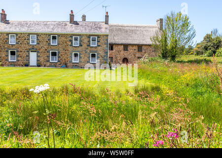 Isola di tipica architettura - Les Caches Farm, Les Villets, Guernsey, Isole del Canale della Manica UK - nuova azienda a metà del XIX C sulla sinistra - vecchia fattoria dal XV C sul lato destro Foto Stock