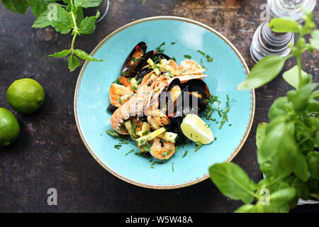 Tagliatelle di Pasta con pesce, gamberi e cozze, scampi, calamari, con aggiunta di vino bianco Foto Stock