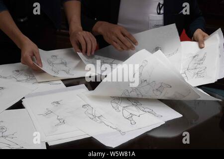 I dipendenti di riordinare i manoscritti di francobolli speciali sul tema della 'Caratteri di Jin Yong Romanzi dell' in corrispondenza di un ramo di Hongkong Post in Hong Kong, mento Foto Stock