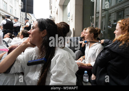 Londra, Regno Unito. Il 30 luglio, 2019. Rivendicare il potere manifestanti con catene di bicicletta intorno ai loro colli, durante una dimostrazione sui combustibili fossili e centrali a gas.i manifestanti stessi incollato a ciò che essi hanno pensato che era il capo ufficio di Drax Power, tuttavia, Drax aveva da tempo spostata fuori. Sono riusciti a chiusura di diverse strade e attirare la presenza della polizia anche se. Credito: SOPA Immagini limitata/Alamy Live News Foto Stock