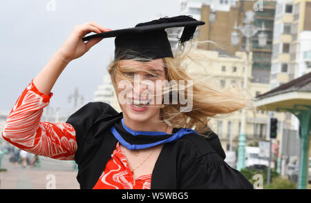 Brighton, Regno Unito. Il 30 luglio, 2019. Hannah Goldsmith celebra la laurea dall'Università di Brighton su un ventoso Mare dopo la cerimonia . Credito: Simon Dack/Alamy Live News Foto Stock