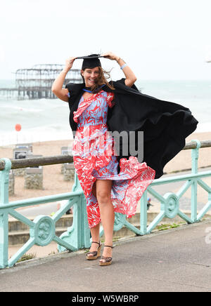 Brighton, Regno Unito. Il 30 luglio, 2019. Lois Green pende sul suo mortaio bordo dopo la laurea dall'Università di Brighton su un ventoso Mare dopo la cerimonia . Credito: Simon Dack/Alamy Live News Foto Stock