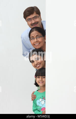 La famiglia si nasconde dietro un cartello Foto Stock