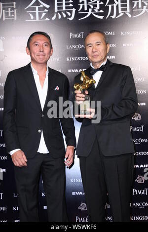 --FILE--regista Taiwanese Hou Hsiao-hsien, destra, pone con il suo trofeo per il miglior regista premio accanto al direttore di Taiwan Doze Niu durante la 52G Foto Stock