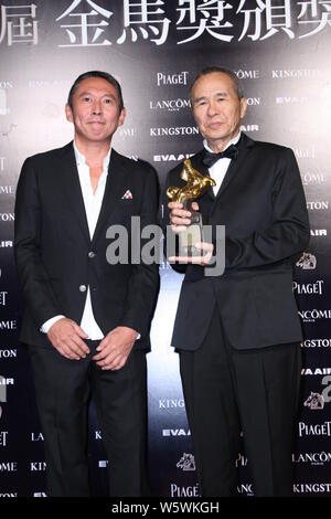 --FILE--regista Taiwanese Hou Hsiao-hsien, destra, pone con il suo trofeo per il miglior regista premio accanto al direttore di Taiwan Doze Niu durante la 52G Foto Stock