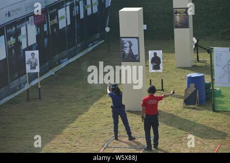 Un Cinese funzionario di polizia compete nel 2° mondo USIP servizio di polizia pistola concorso di ripresa in Foshan City, a sud della Cina di provincia di Guangdong, 1 Foto Stock