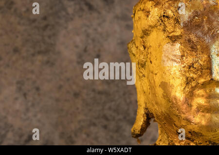 Statua di Buddha ricoperta con carta d'oro vicino. Copia spazio a sinistra Foto Stock