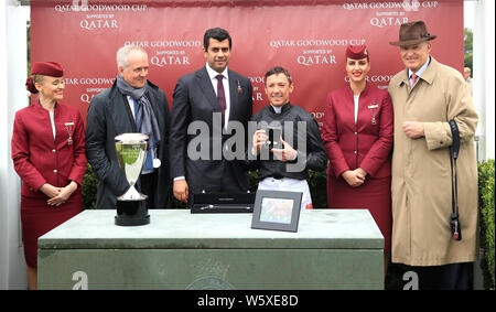 Proprietario Bjorn Nielsen (seconda a sinistra), Jockey Frankie Dettori (al centro a destra) e il Trainer John Gosden (a destra) con il trofeo dopo la vittoria del Qatar Goodwood Cup Stakes su Stradivarius durante il giorno uno del Qatar Goodwood Festival di Goodwood Racecourse, Chichester. Foto Stock