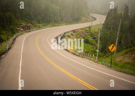 Avvolgimento Trans Canada highway attraverso la nebbia e umidità estiva compresa off Lago Superior North Shore. Foto Stock