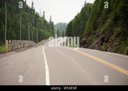 Avvolgimento Trans Canada highway attraverso la nebbia e umidità estiva compresa off Lago Superior North Shore. Foto Stock