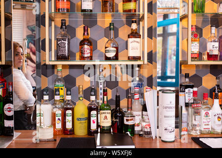 Doncaster, Regno Unito - 11 Maggio 2019: cameriera riflessa in specchio dietro il bar con bottiglie di alcol f sul display a La Boca ristorante & steakhouse, 1 Antille Foto Stock