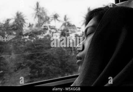 Thailandese giovane donna che dorme pacificamente in un treno a Bangkok, in Thailandia. Foto Stock