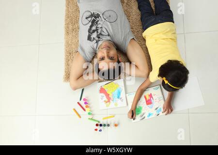 Vista ad alto angolo di un uomo che assiste sua figlia studiare Foto Stock