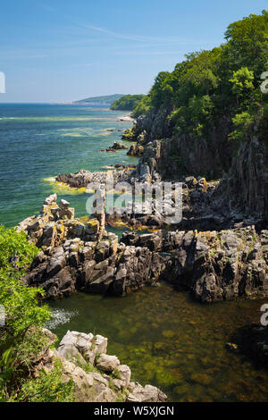 Aspre formazioni rocciose di Helligdomsklipperne guardando verso Gudhjem, vicino Gudhjem, Bornholm, Mar Baltico, Danimarca, Europa Foto Stock