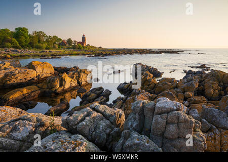 Gamle Svaneke Fyr faro e costa rocciosa lungo la costa orientale di sunrise, Svaneke, isola di Bornholm, Mar Baltico, Danimarca, Europa Foto Stock