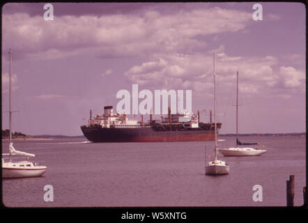 Barche a vela giro in ancoraggio sul RARITAN YACHT CLUB IN PERTH AMBOY, dove il fiume RARITAN UNISCE LA ARTHUR KILL. Una petroliera ESSO LASCIA LA ARTHUR KILL PER LA BAIA Foto Stock