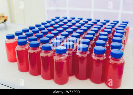 Vari succhi di frutta in bottiglie di colore rosso. Foto Stock