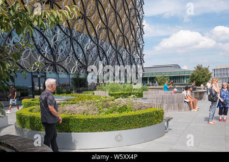 Visitatori godendo un sole estivo sulla biblioteca di Birmingham roof garden Foto Stock