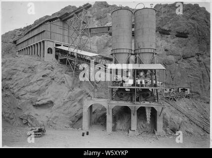 Sei società' elevato livello centrali di betonaggio in via di completamento a Nevada approccio. Lo storage aggregato visto a sinistra, impianto di miscelazione a destra. Silos di acciaio di miscelazione di cui sopra sono impianti di stoccaggio di cemento.; Portata e contenuto: fotografia dal volume due di una serie di album di foto per documentare la costruzione della Diga di Hoover, Boulder City, Nevada. Foto Stock