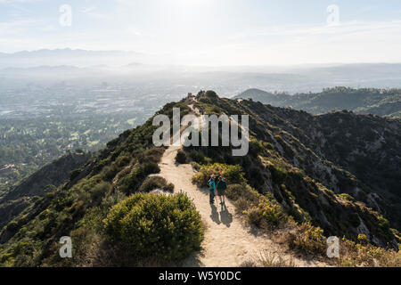 Los Angeles, California, Stati Uniti d'America - 28 Luglio 2019: la mattina presto gli escursionisti in pausa su Griffith Park East ridge trail al di sopra di Glendale e il centro cittadino di Los Angeles. Foto Stock